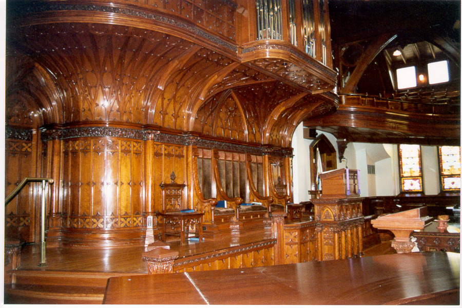 A church interior with elaborate historic wood work.
