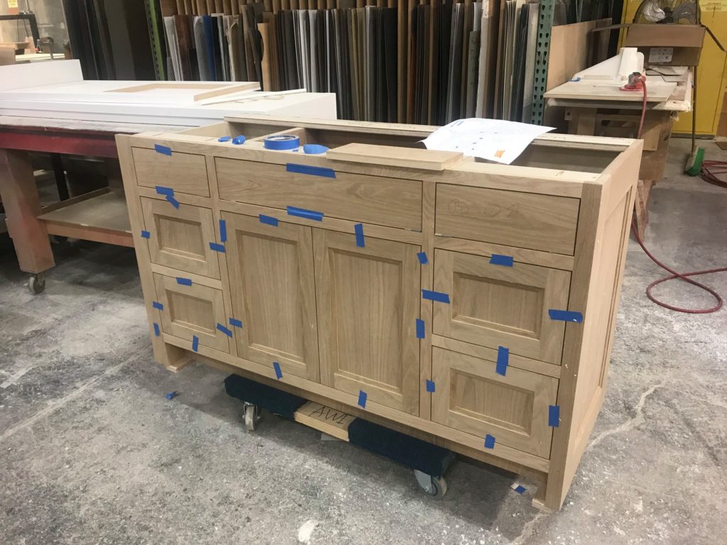 An almost finished cabinet in a woodshop.